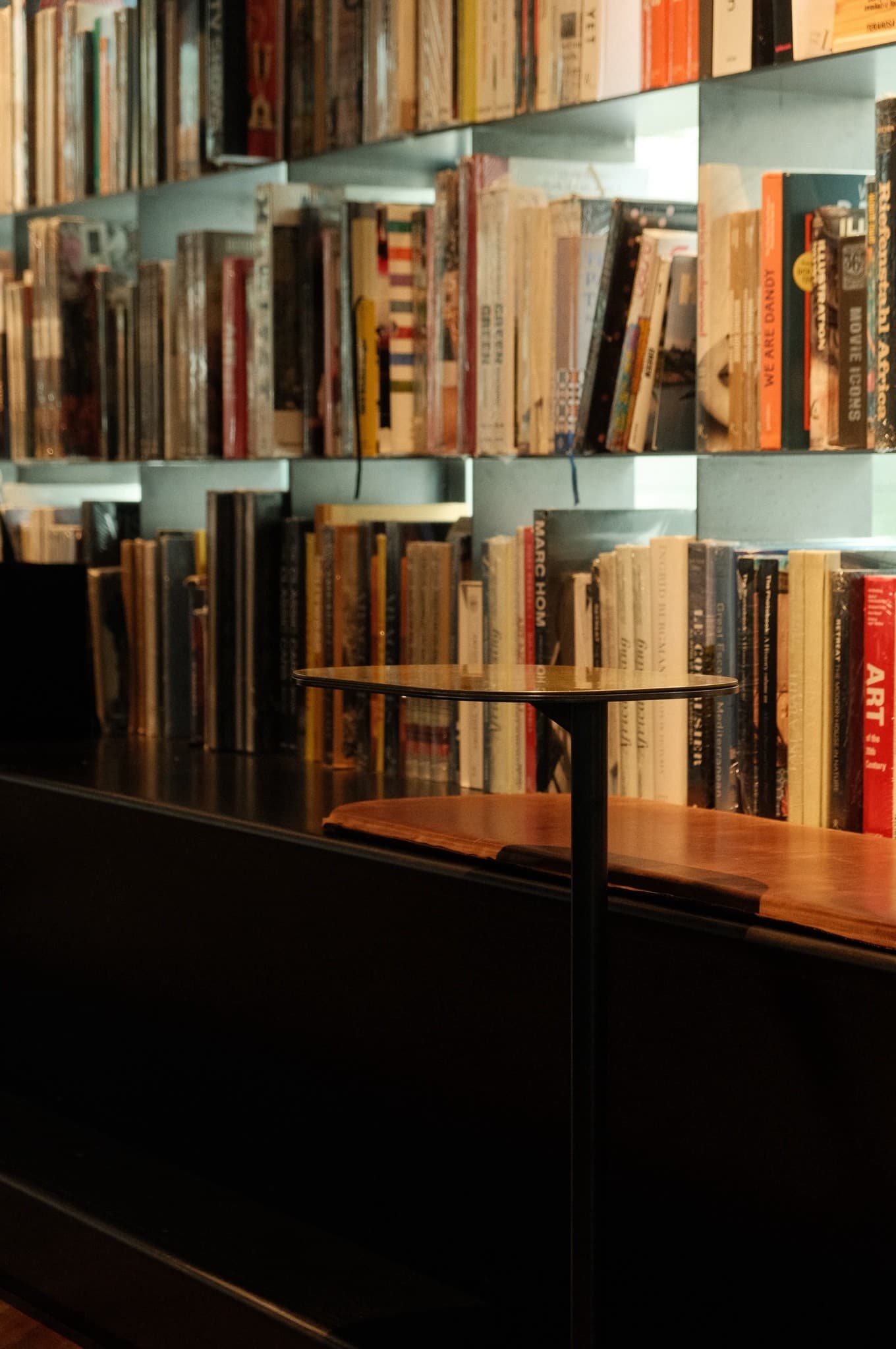 Shelves of art books behind a small café table